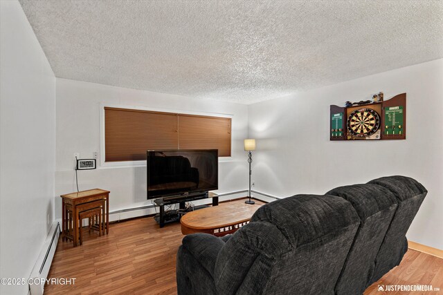 4433 San Ernesto Ave # 104, Anchorage, AK 99508 - living room with baseboard heating, a textured ceiling, wood finished floors, and baseboards