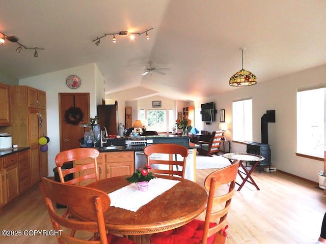 4259 Shirley Ct, Homer, AK 99603 - dining space featuring light wood-type flooring, lofted ceiling, a wood stove, track lighting, and a ceiling fan