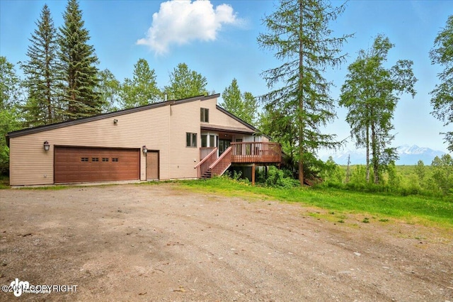 4821 S Outrigger Dr, Wasilla, AK 99654 - view of property exterior with a wooden deck, stairs, a garage, and driveway