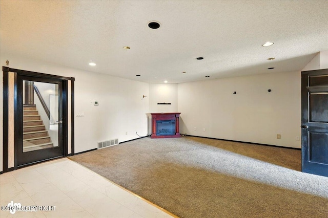 4821 S Outrigger Dr, Wasilla, AK 99654 - empty room featuring a fireplace, light carpet, recessed lighting, baseboards, and a textured ceiling