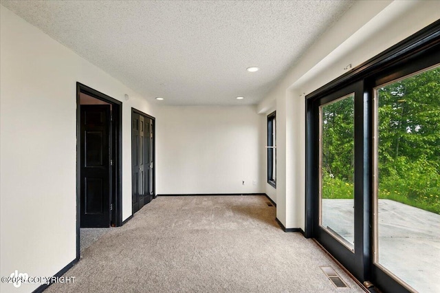 4821 S Outrigger Dr, Wasilla, AK 99654 - spare room with light colored carpet, a textured ceiling, baseboards, and recessed lighting