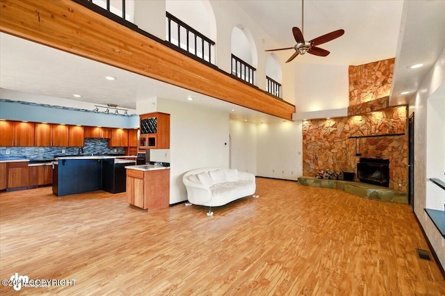 4821 S Outrigger Dr, Wasilla, AK 99654 - living area with a towering ceiling, light wood-style flooring, ceiling fan, a fireplace, and recessed lighting