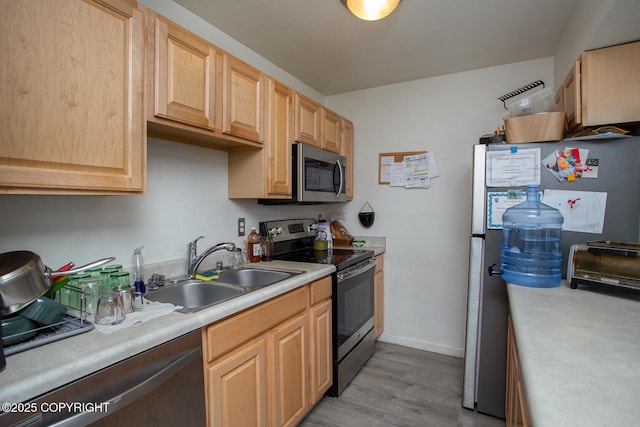 1701 Russian Jack Dr # D3, Anchorage, AK 99508 - kitchen featuring appliances with stainless steel finishes, a sink, light countertops, and light brown cabinetry