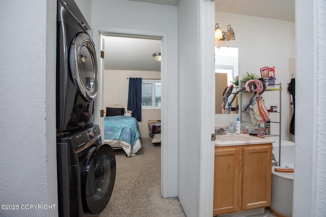 1701 Russian Jack Dr # D3, Anchorage, AK 99508 - laundry room featuring stacked washer and clothes dryer, a textured ceiling, light carpet, and cabinet space