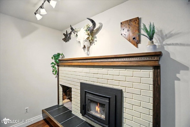 12900 Wellsford Cir, Anchorage, AK 99516 - detailed view of a fireplace, wood finished floors, baseboards, and rail lighting