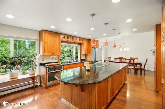 12900 Wellsford Cir, Anchorage, AK 99516 - kitchen featuring appliances with stainless steel finishes, a baseboard heating unit, plenty of natural light, light wood finished floors, and recessed lighting