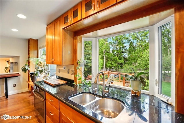 12900 Wellsford Cir, Anchorage, AK 99516 - kitchen featuring a sink, brown cabinets, baseboards, wall oven, and glass insert cabinets