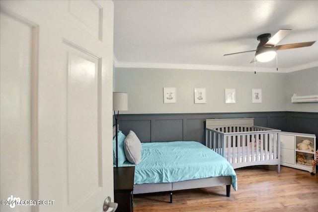 12900 Wellsford Cir, Anchorage, AK 99516 - bedroom featuring crown molding, wood finished floors, wainscoting, and ceiling fan