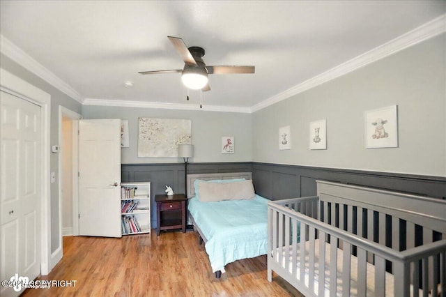 12900 Wellsford Cir, Anchorage, AK 99516 - bedroom with ornamental molding, wood finished floors, a wainscoted wall, and ceiling fan