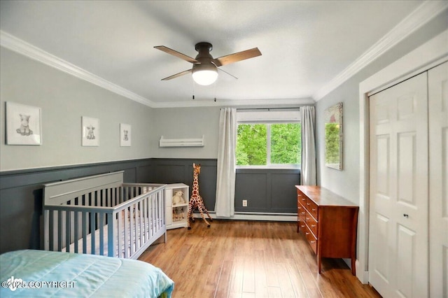 12900 Wellsford Cir, Anchorage, AK 99516 - bedroom featuring crown molding, wood finished floors, a baseboard radiator, a closet, and a ceiling fan