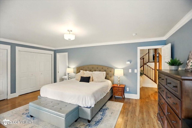 12900 Wellsford Cir, Anchorage, AK 99516 - bedroom featuring crown molding, baseboards, wood finished floors, and two closets
