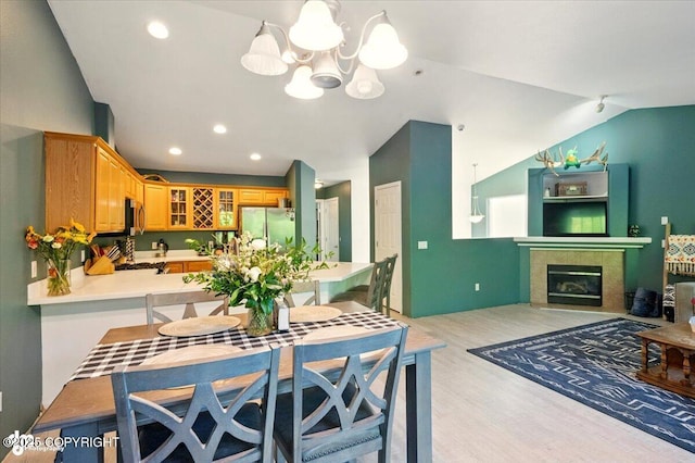 11437 Spyglass Hill Cir, Anchorage, AK 99515 - dining space with vaulted ceiling, light wood finished floors, a chandelier, recessed lighting, and a tile fireplace