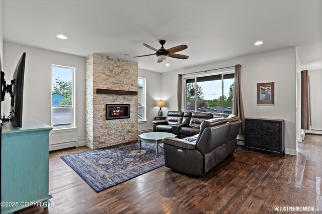 1506 M St, Anchorage, AK 99501 - living room with baseboard heating, wood-type flooring, a ceiling fan, a stone fireplace, and plenty of natural light