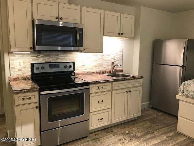 1506 M St, Anchorage, AK 99501 - kitchen with stainless steel appliances, a sink, tasteful backsplash, wood finished floors, and dark countertops