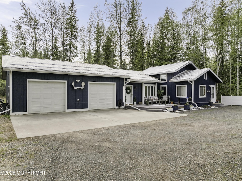2072 Persinger Dr, North Pole, AK 99705 - view of front facade with driveway, a garage, and view of wooded area