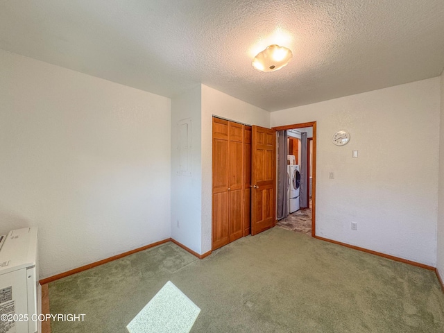 124 Mountain View Dr, Homer, AK 99603 - unfurnished bedroom featuring washer / clothes dryer, light carpet, a closet, a textured ceiling, and baseboards