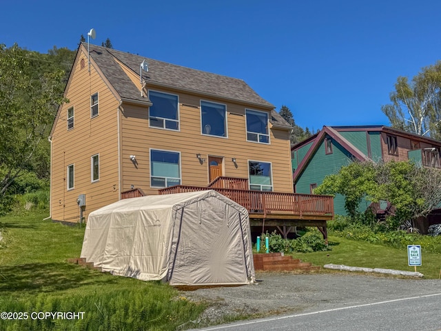 124 Mountain View Dr, Homer, AK 99603 - view of front of home with a wooden deck, a front yard, and roof with shingles