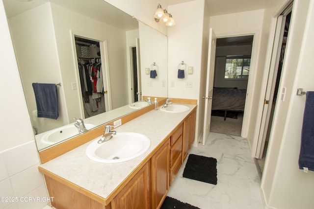 3208 E Serendipity Loop, Wasilla, AK 99654 - ensuite bathroom with marble look tile flooring, double vanity, and a spacious closet