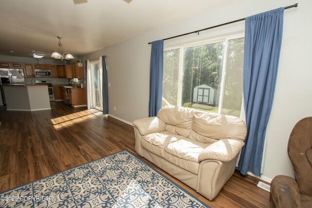 3208 E Serendipity Loop, Wasilla, AK 99654 - living area with a chandelier, dark wood-style floors, and baseboards
