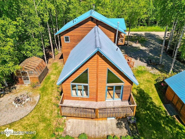 5680 W Birch Harbor Dr, Wasilla, AK 99623 - rear view of house featuring a greenhouse, an outdoor structure, a yard, a wooded view, and metal roof