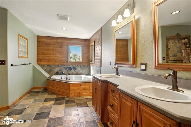 5680 W Birch Harbor Dr, Wasilla, AK 99623 - full bathroom with double vanity, a garden tub, stone tile flooring, baseboards, and recessed lighting