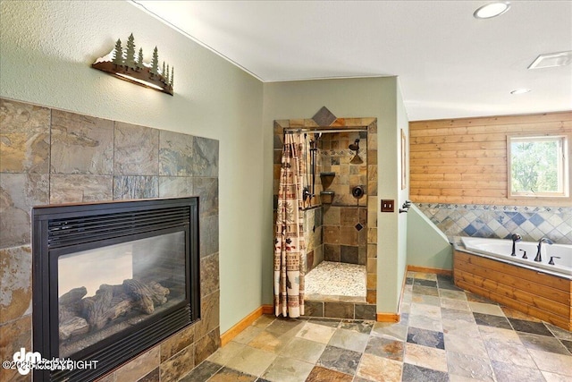 5680 W Birch Harbor Dr, Wasilla, AK 99623 - bathroom with a shower stall, a bath, baseboards, a tile fireplace, and recessed lighting