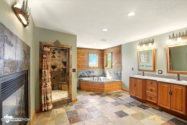 5680 W Birch Harbor Dr, Wasilla, AK 99623 - full bathroom featuring a tile shower, a bath, double vanity, a tiled fireplace, and recessed lighting