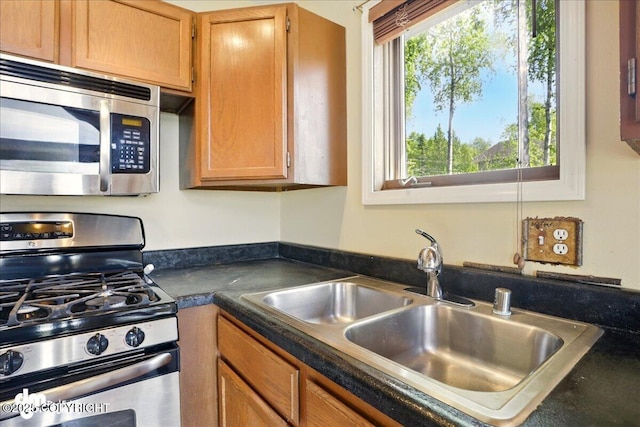 5680 W Birch Harbor Dr, Wasilla, AK 99623 - kitchen featuring stainless steel appliances, a sink, dark countertops, and brown cabinetry