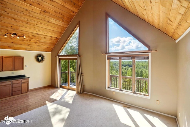 5680 W Birch Harbor Dr, Wasilla, AK 99623 - unfurnished living room with wooden ceiling, plenty of natural light, baseboards, light carpet, and high vaulted ceiling