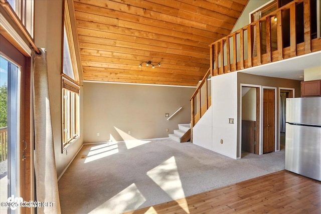 5680 W Birch Harbor Dr, Wasilla, AK 99623 - unfurnished living room with wooden ceiling, stairs, high vaulted ceiling, wood finished floors, and carpet floors