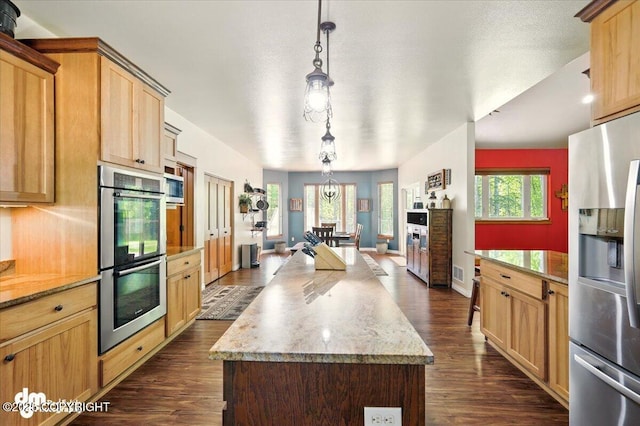 6325 S Hayfield Rd, Wasilla, AK 99654 - kitchen featuring stainless steel appliances, dark wood-style flooring, a center island, pendant lighting, and light brown cabinets
