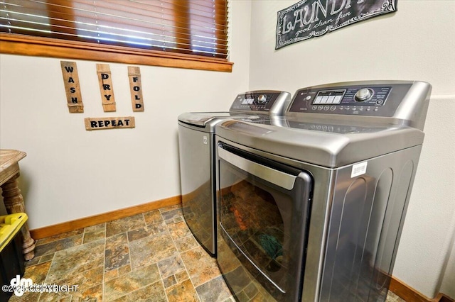 6325 S Hayfield Rd, Wasilla, AK 99654 - washroom featuring washer and clothes dryer, baseboards, and stone tile flooring
