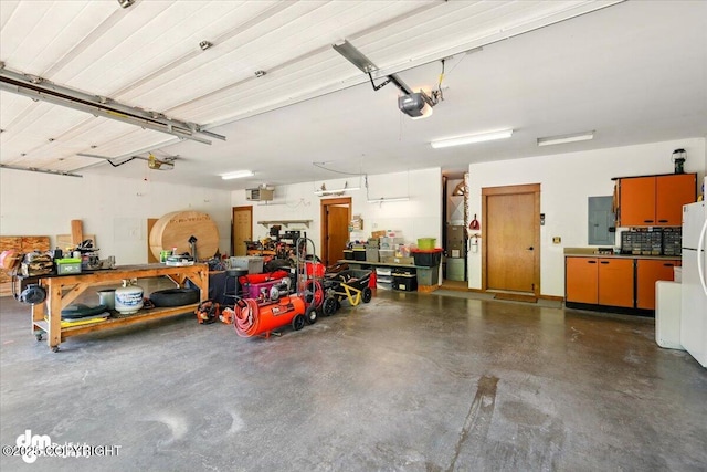 6325 S Hayfield Rd, Wasilla, AK 99654 - garage with electric panel, a workshop area, a garage door opener, and freestanding refrigerator