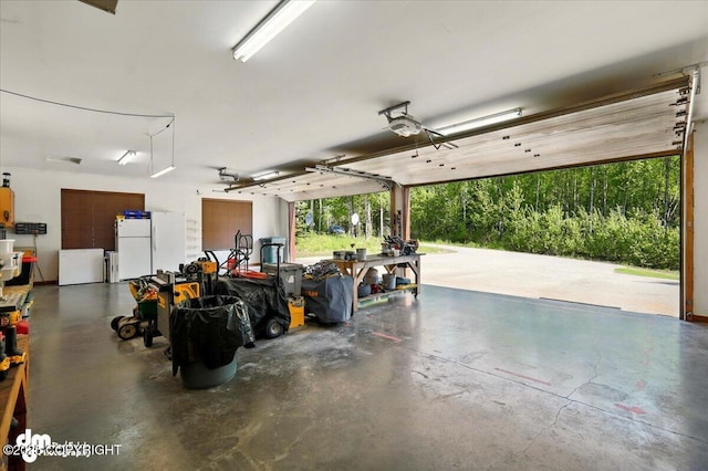 6325 S Hayfield Rd, Wasilla, AK 99654 - garage featuring a garage door opener and freestanding refrigerator