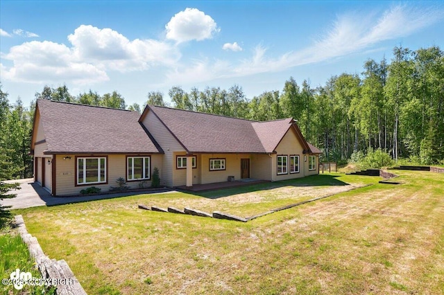 6325 S Hayfield Rd, Wasilla, AK 99654 - back of house with a yard, an attached garage, driveway, and roof with shingles
