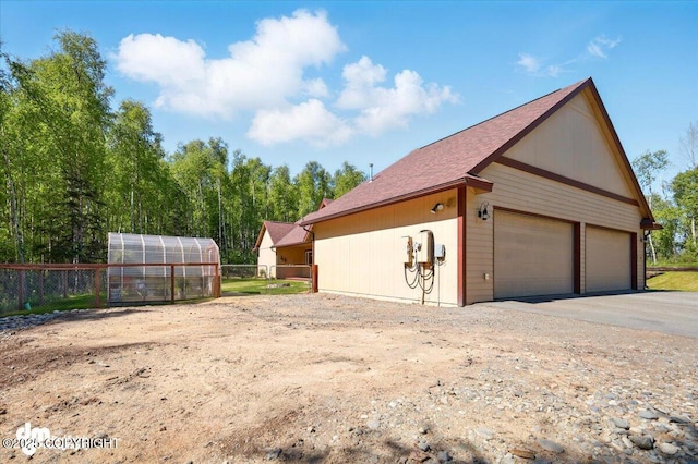 6325 S Hayfield Rd, Wasilla, AK 99654 - view of home's exterior featuring an exterior structure, a detached garage, an outdoor structure, and roof with shingles