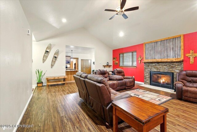 6325 S Hayfield Rd, Wasilla, AK 99654 - living area featuring wood finished floors, a ceiling fan, a stone fireplace, baseboards, and high vaulted ceiling