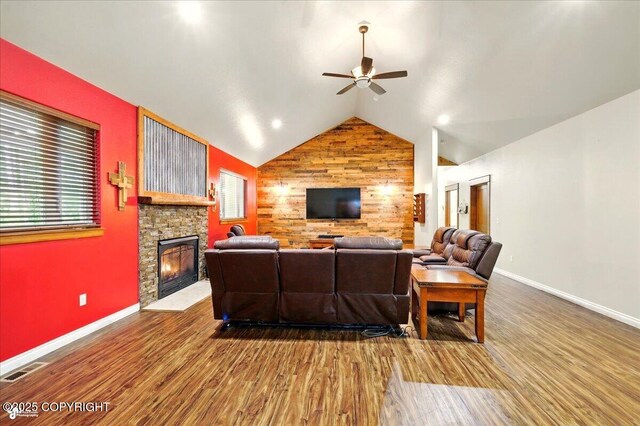 6325 S Hayfield Rd, Wasilla, AK 99654 - living room featuring a ceiling fan, wood finished floors, baseboards, lofted ceiling, and a stone fireplace