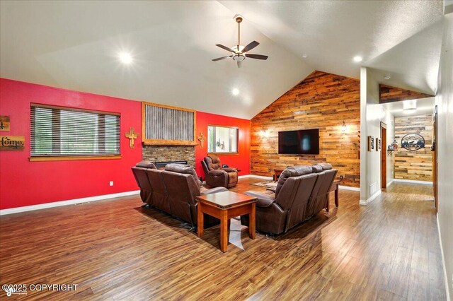 6325 S Hayfield Rd, Wasilla, AK 99654 - living room with a ceiling fan, wood finished floors, a stone fireplace, baseboards, and high vaulted ceiling