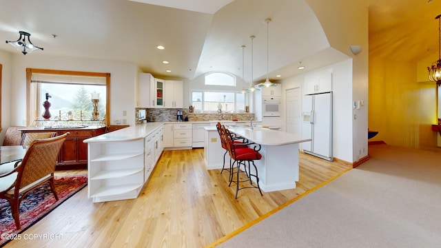 22 Sing Lee Aly # 5, Petersburg, AK 99833 - kitchen featuring white appliances, vaulted ceiling, glass insert cabinets, light countertops, and open shelves