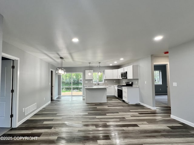 8201 W Teal Cir, Wasilla, AK 99623 - kitchen with appliances with stainless steel finishes, recessed lighting, dark wood-style floors, white cabinets, and baseboards