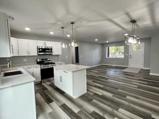 8201 W Teal Cir, Wasilla, AK 99623 - kitchen with stainless steel appliances, a sink, recessed lighting, dark wood-style floors, and white cabinetry