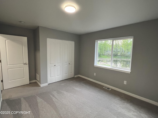 8201 W Teal Cir, Wasilla, AK 99623 - unfurnished bedroom featuring baseboards, a closet, and carpet floors