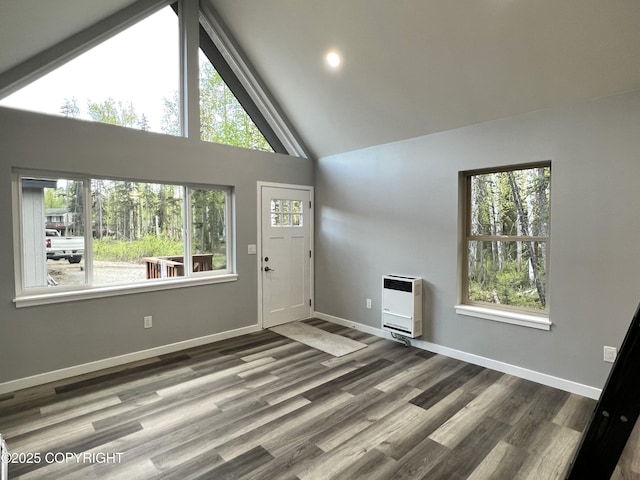 8201 W Teal Cir, Wasilla, AK 99623 - unfurnished living room featuring heating unit, high vaulted ceiling, wood finished floors, and baseboards