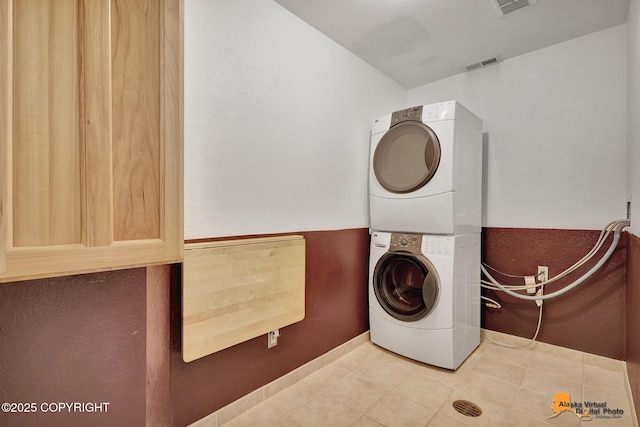15245 Longbow Dr, Anchorage, AK 99516 - laundry room featuring stacked washing machine and dryer, baseboards, and tile patterned flooring