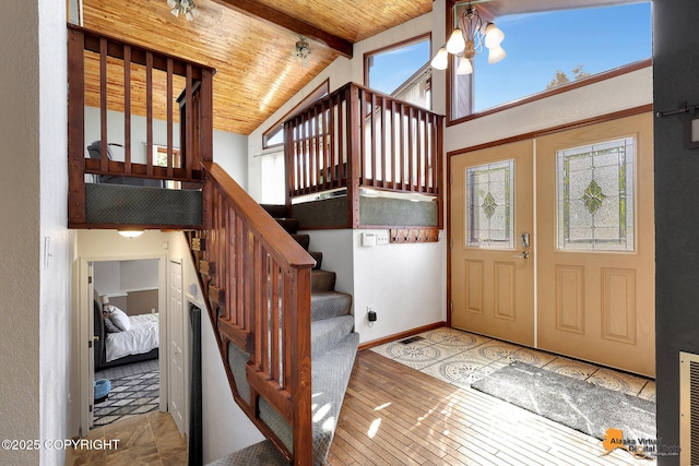 15245 Longbow Dr, Anchorage, AK 99516 - foyer entrance with healthy amount of natural light, wooden ceiling with exposed beams, stairway, hardwood / wood-style flooring, and high vaulted ceiling
