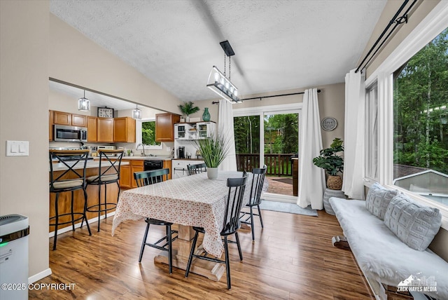 19705 Citation Rd, Eagle River, AK 99577 - dining room featuring a textured ceiling, light wood finished floors, and vaulted ceiling