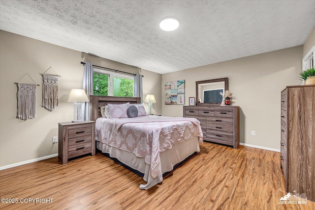 19705 Citation Rd, Eagle River, AK 99577 - bedroom featuring light wood-type flooring, baseboards, and a textured ceiling