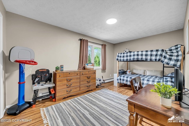 19705 Citation Rd, Eagle River, AK 99577 - bedroom featuring wood finished floors, baseboard heating, baseboards, and a textured ceiling