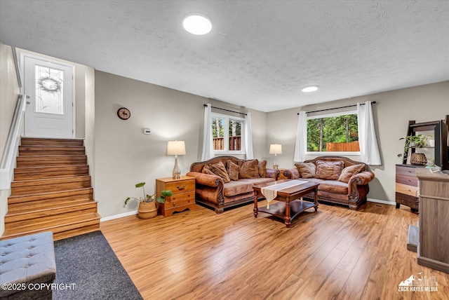 19705 Citation Rd, Eagle River, AK 99577 - living area featuring a textured ceiling, wood finished floors, baseboards, and stairs